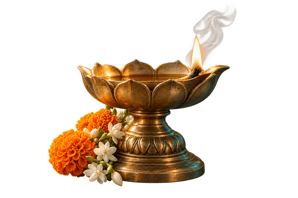 An antique brass diya with a small flame, marigolds, jasmine, and delicate smoke